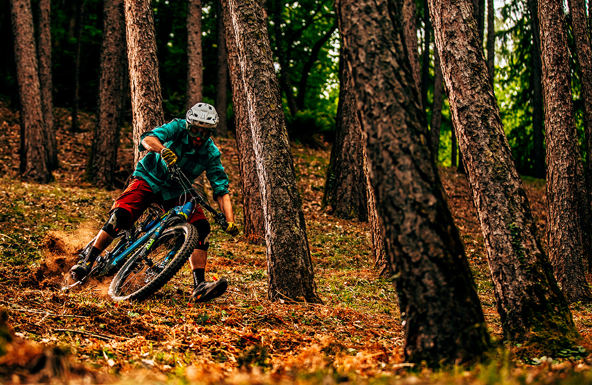 Ciclista che pratica e-MTB Enduro nei sentieri dei boschi delle Orobie