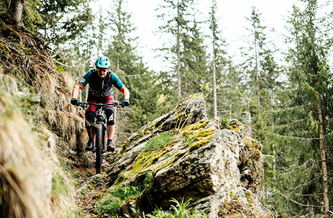 Ciclista in e-Mtb in un Sentiero Stretto e Tortuoso della Valmalenco