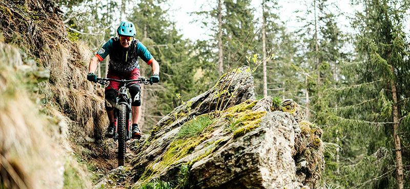 Ciclista in e-Mtb in un Sentiero Stretto e Tortuoso della Valmalenco